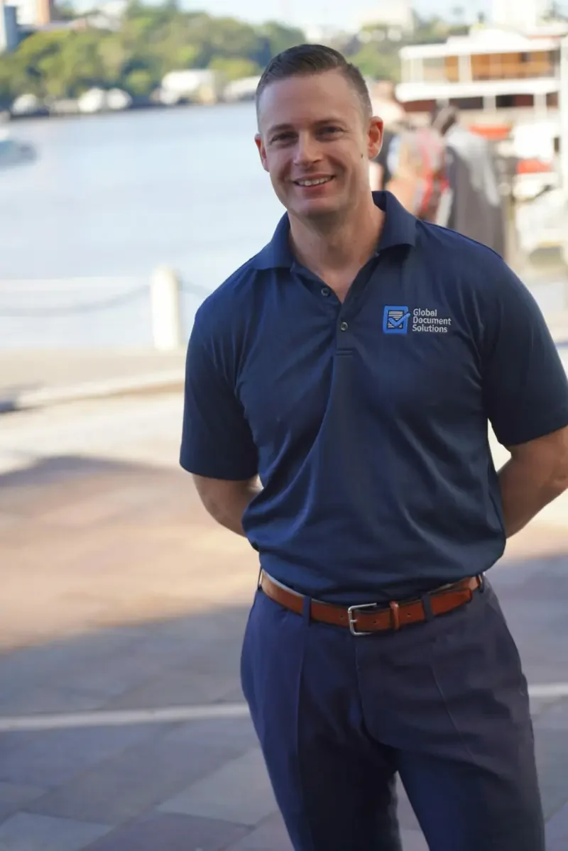 Cyrus Dickie, founder of Global Document Solutions, standing outside in a navy work polo